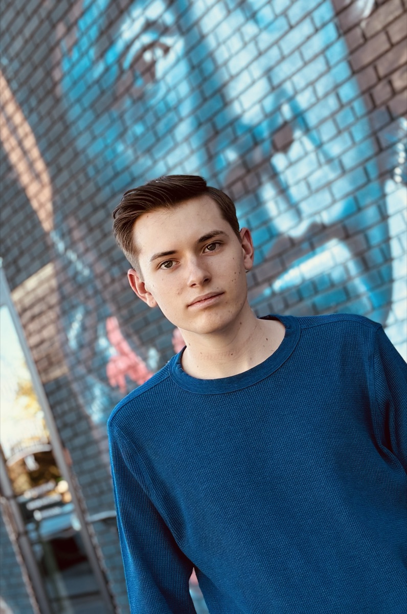 Etienne Pema La Fleur in front of a painted mural